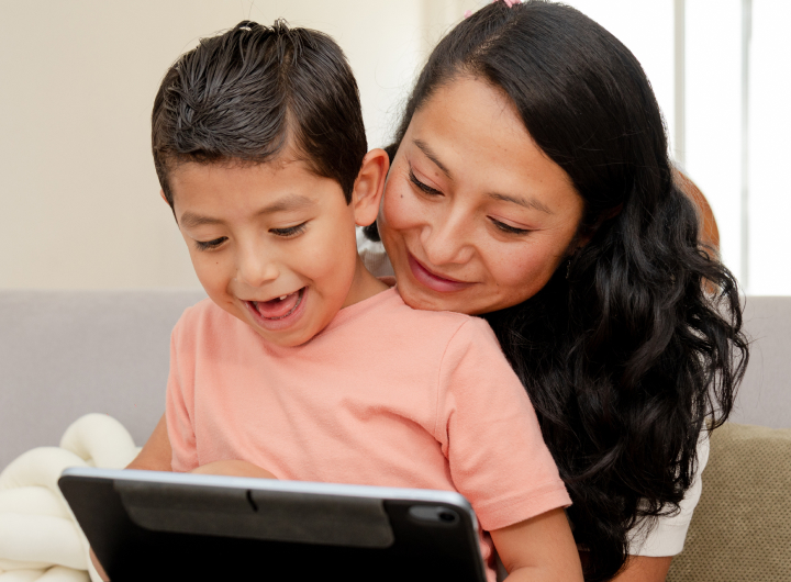 Mom hugs son who is on a tablet, getting close can help with screen time tantrums
